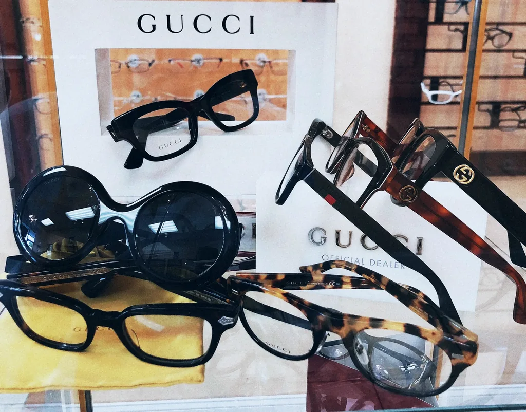 Monturas Gucci de carey y negras sobre una vitrina, con el letrero de Gucci detrás